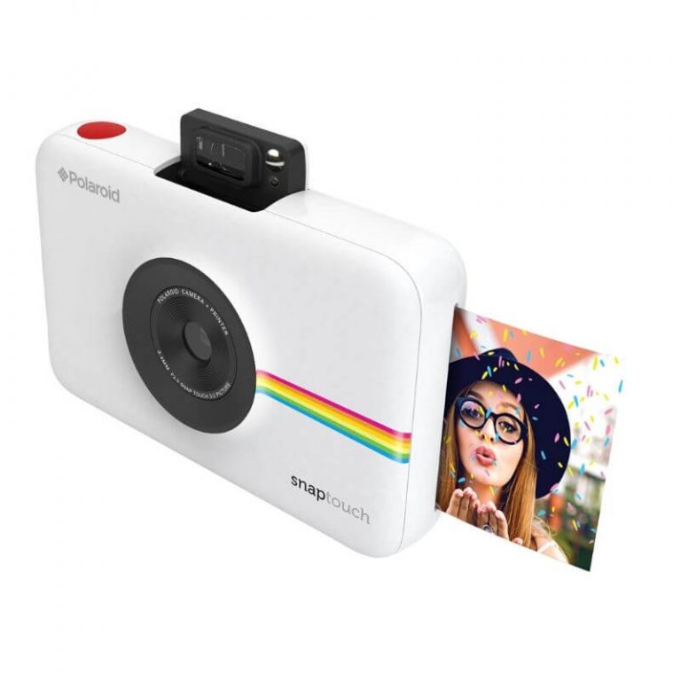 Tarrallisia valokuvia tulostava Polaroid-kamera ja runsas kuvausrekvisiitta.