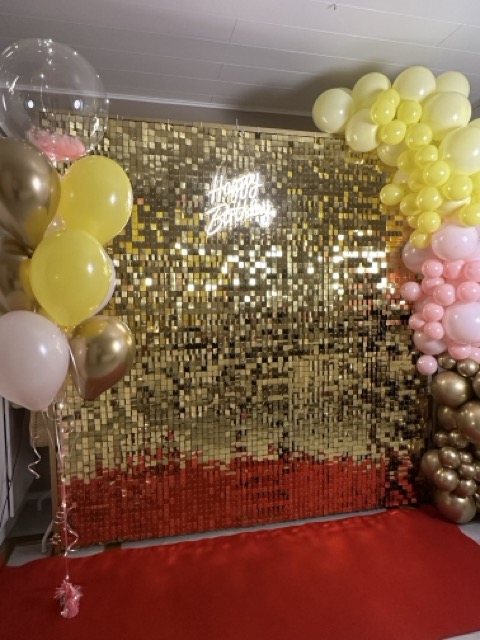 Kuvausseinä vuokraus. Tässä kultainen paljettiseinä, punainen matto, Happy Birthday valokyltti, ilmapallokimppu ja ilmapallokaari vielä lisäsomisteena. Paljettiseinään saatavilla eri värejä. # kultainen paljettiseinä